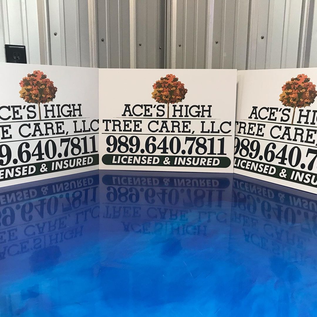 Three signs for ace 's high tree care are sitting on a table.
