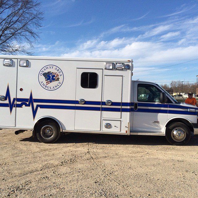 A white and blue ambulance with the word emergency on the side