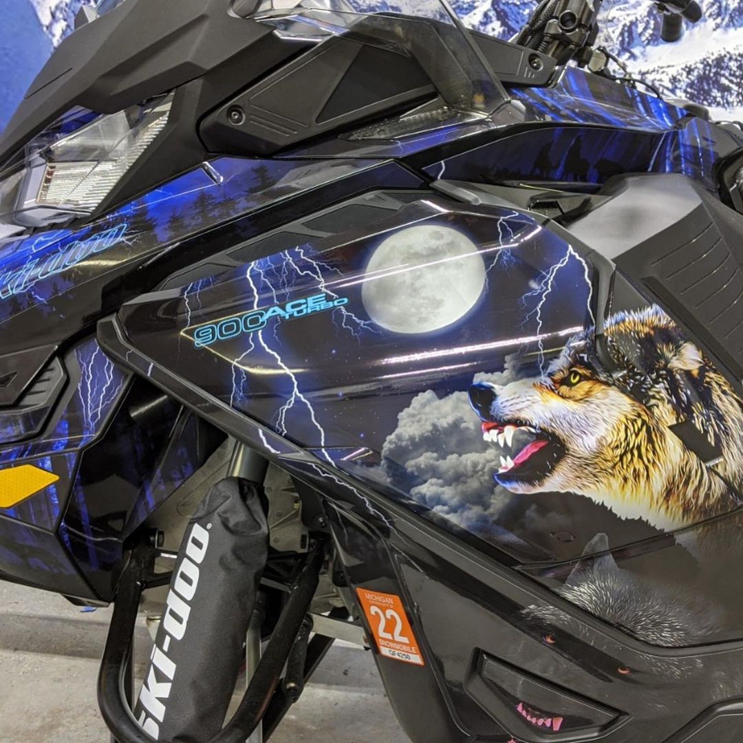 A snowmobile with a wolf on the side of it