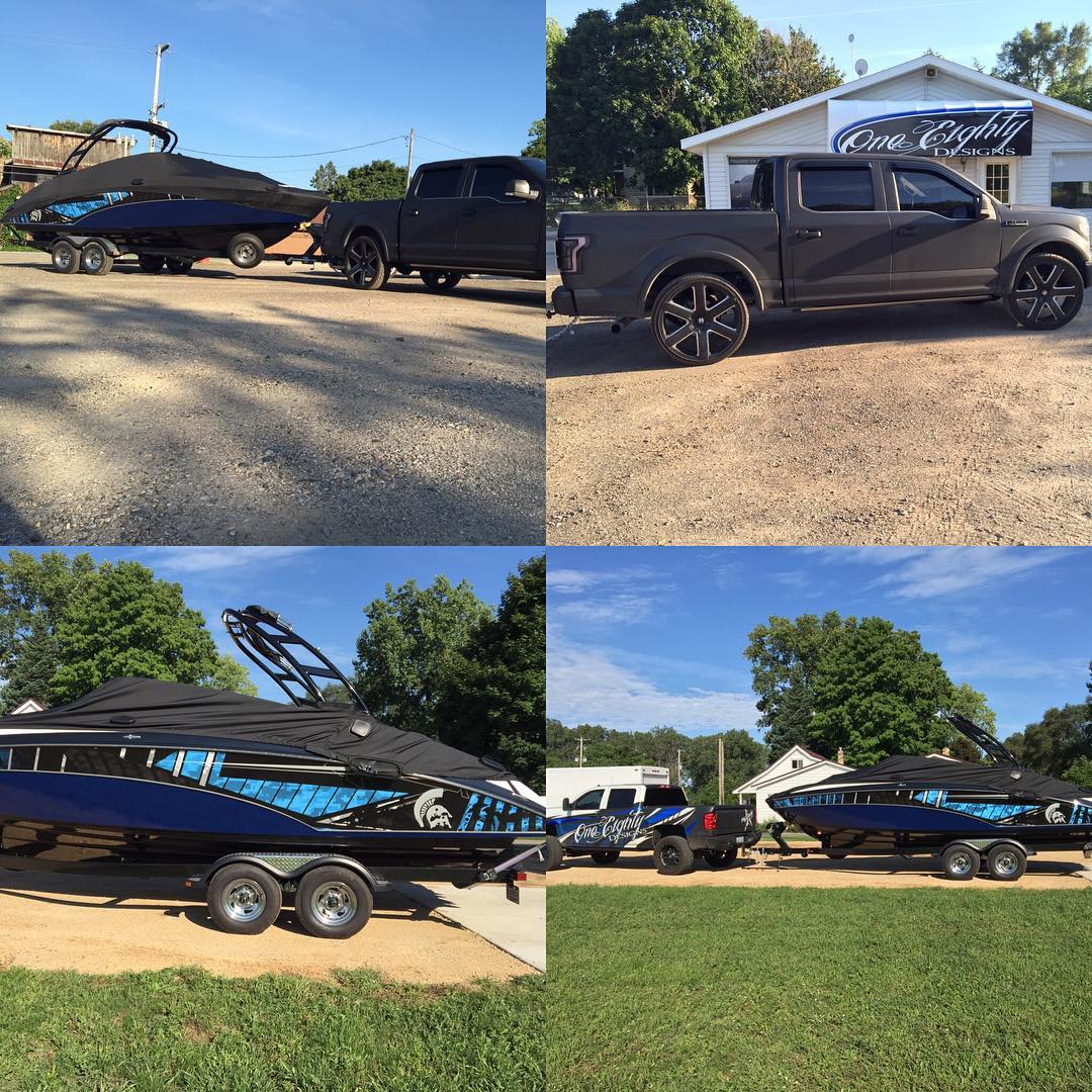 A boat is being towed by a truck in a parking lot