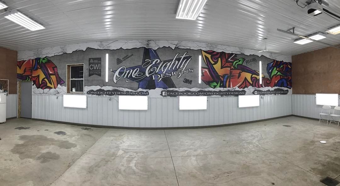 A large empty room with a mural on the wall.