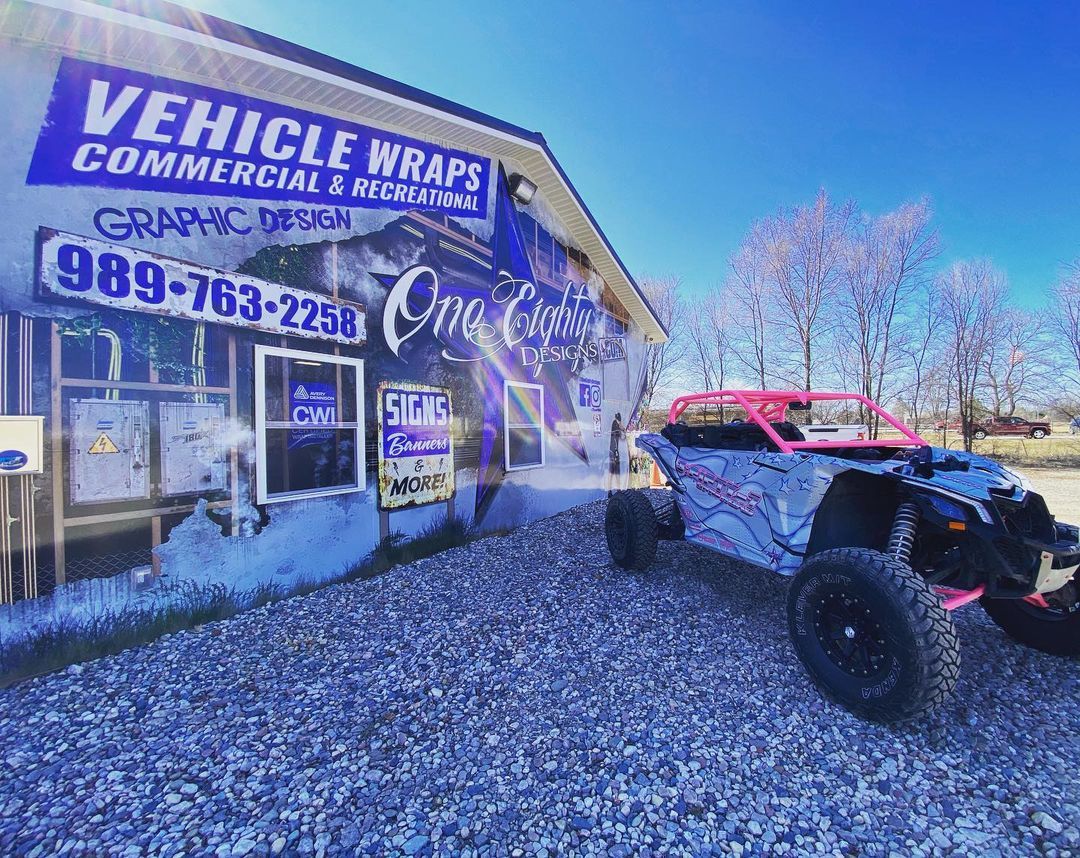 A red and white atv is parked in front of a building.