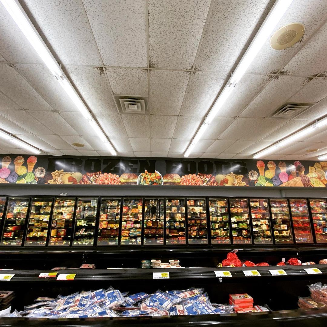The inside of a grocery store with a ceiling that has a picture of fruits and vegetables on it