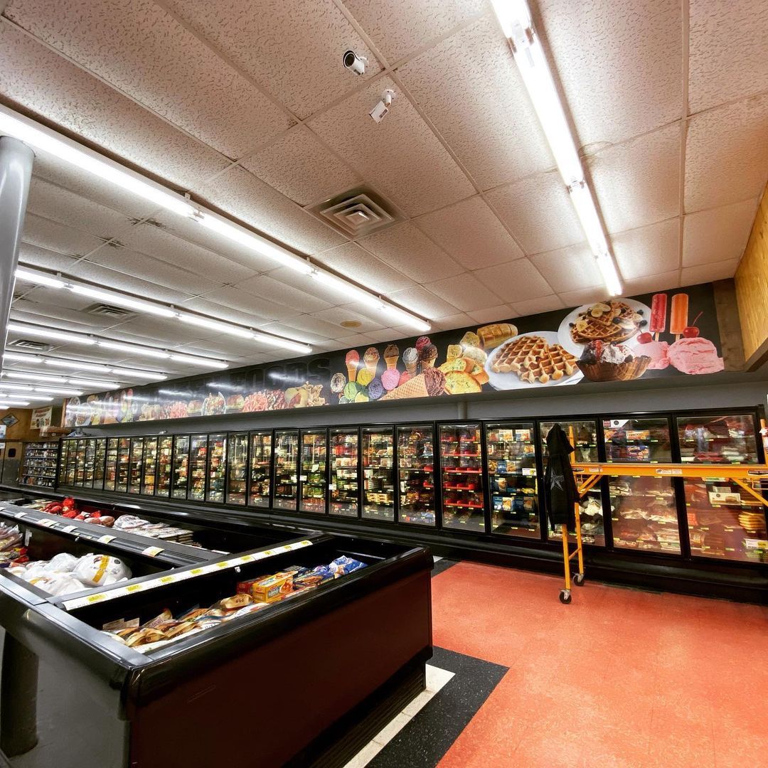 The inside of a grocery store with a large mural on the wall
