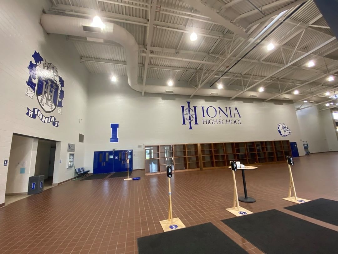 A large empty gym with a logo on the wall.