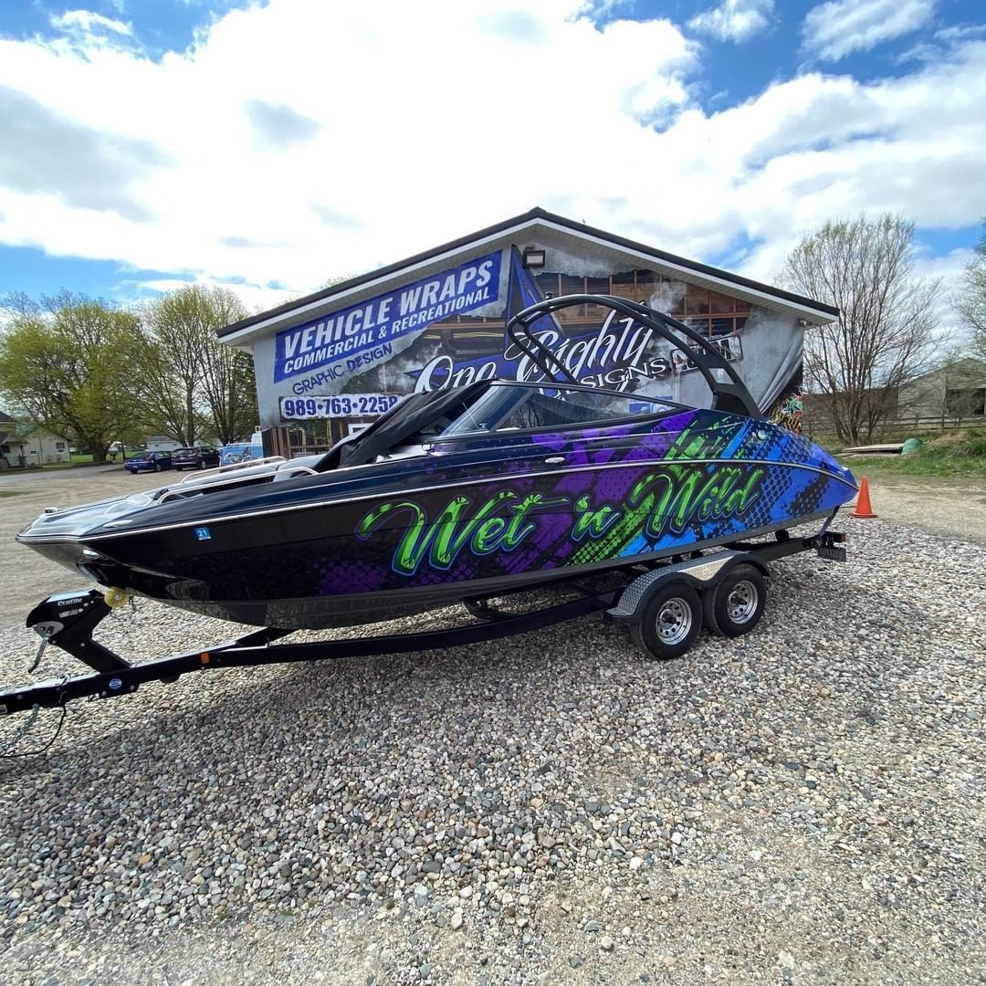 A boat is parked on a trailer in front of a building.