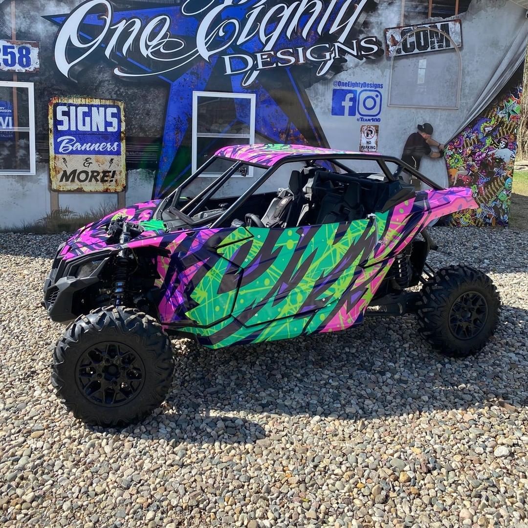 A colorful atv is parked in front of a building.