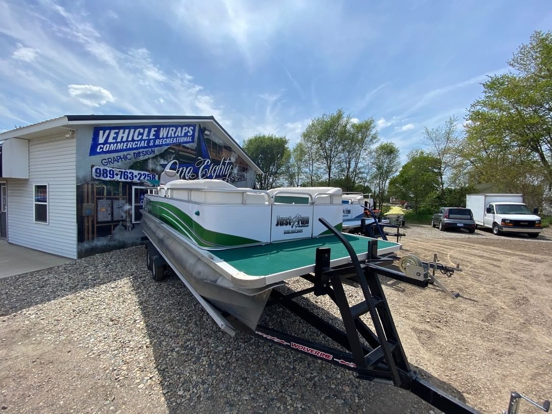 A pontoon boat is parked in front of a building.