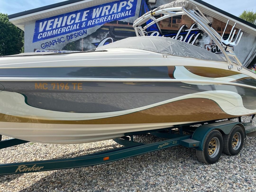 A boat is parked on a trailer in front of a building.