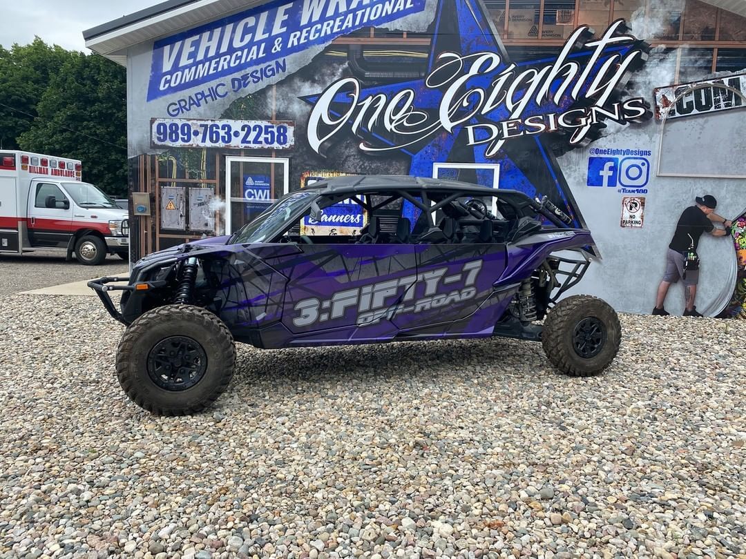 A purple atv is parked in front of a building.