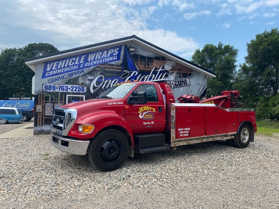 A red tow truck is parked in front of a building.