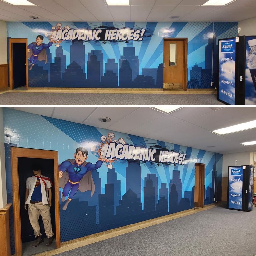 A hallway with a mural on the wall that says academic heroes