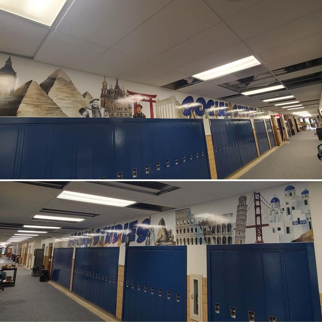 A hallway with blue lockers and a mural on the wall