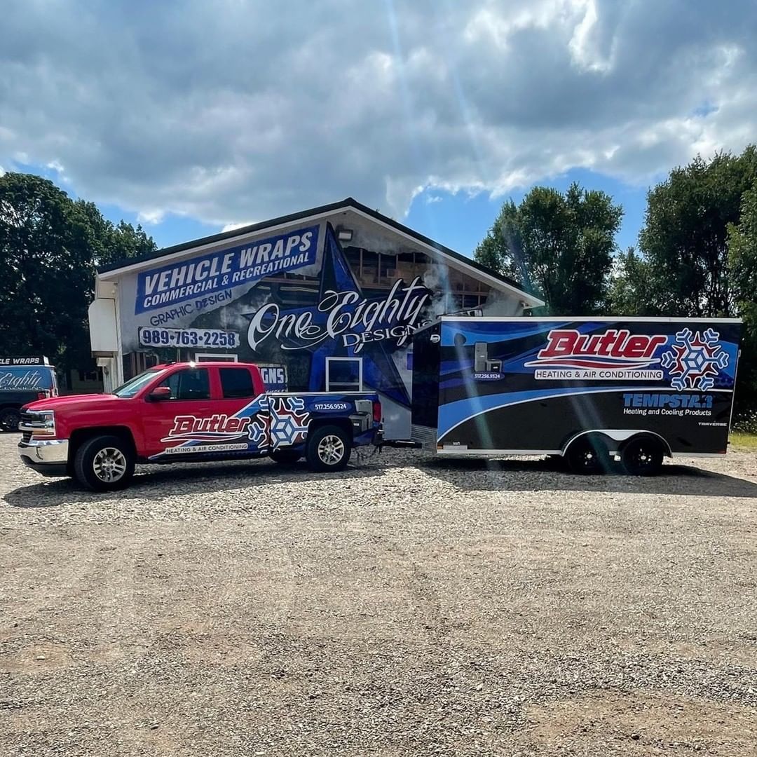 A truck and trailer are parked in front of a building.