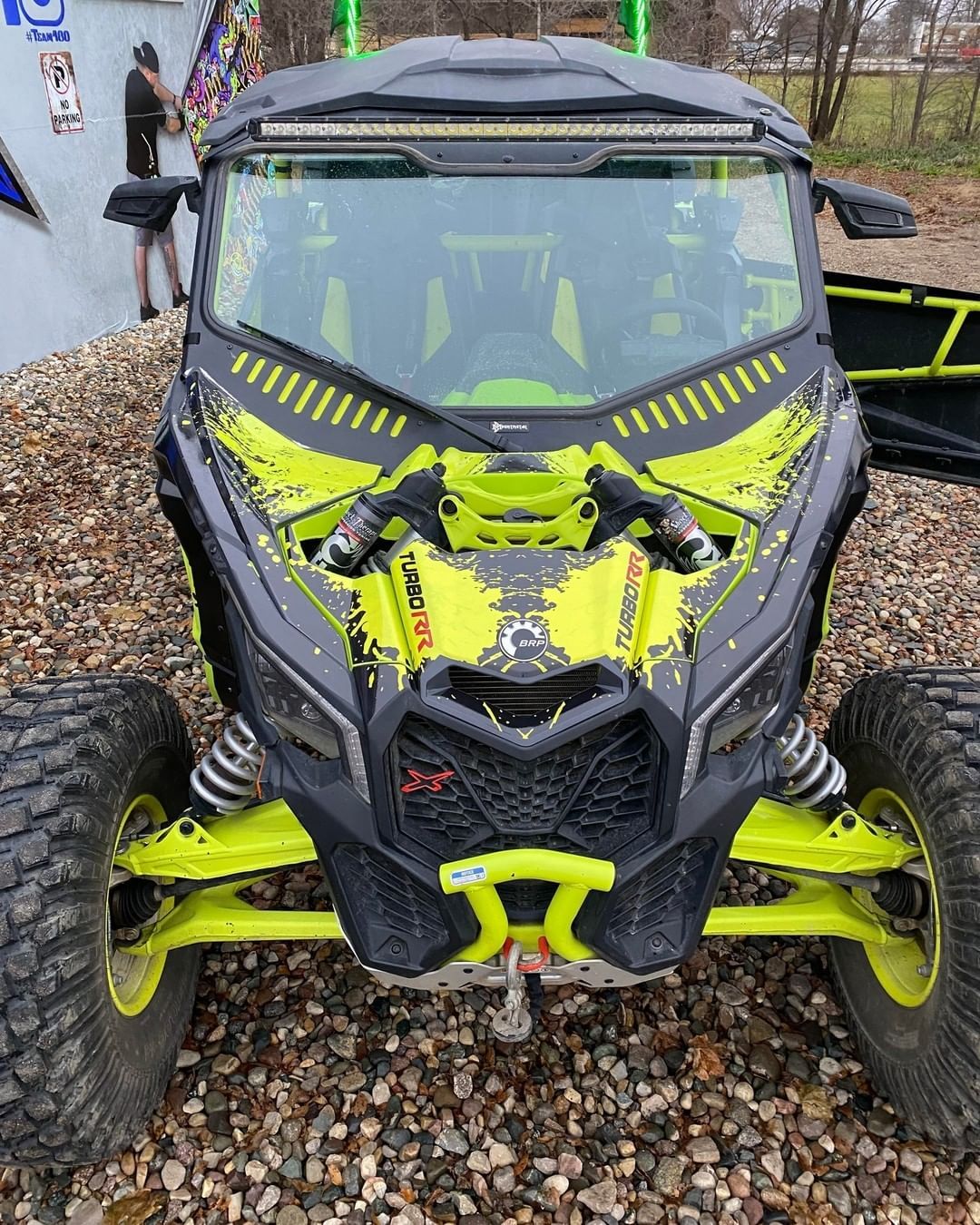 A yellow and black atv is parked on a gravel road.