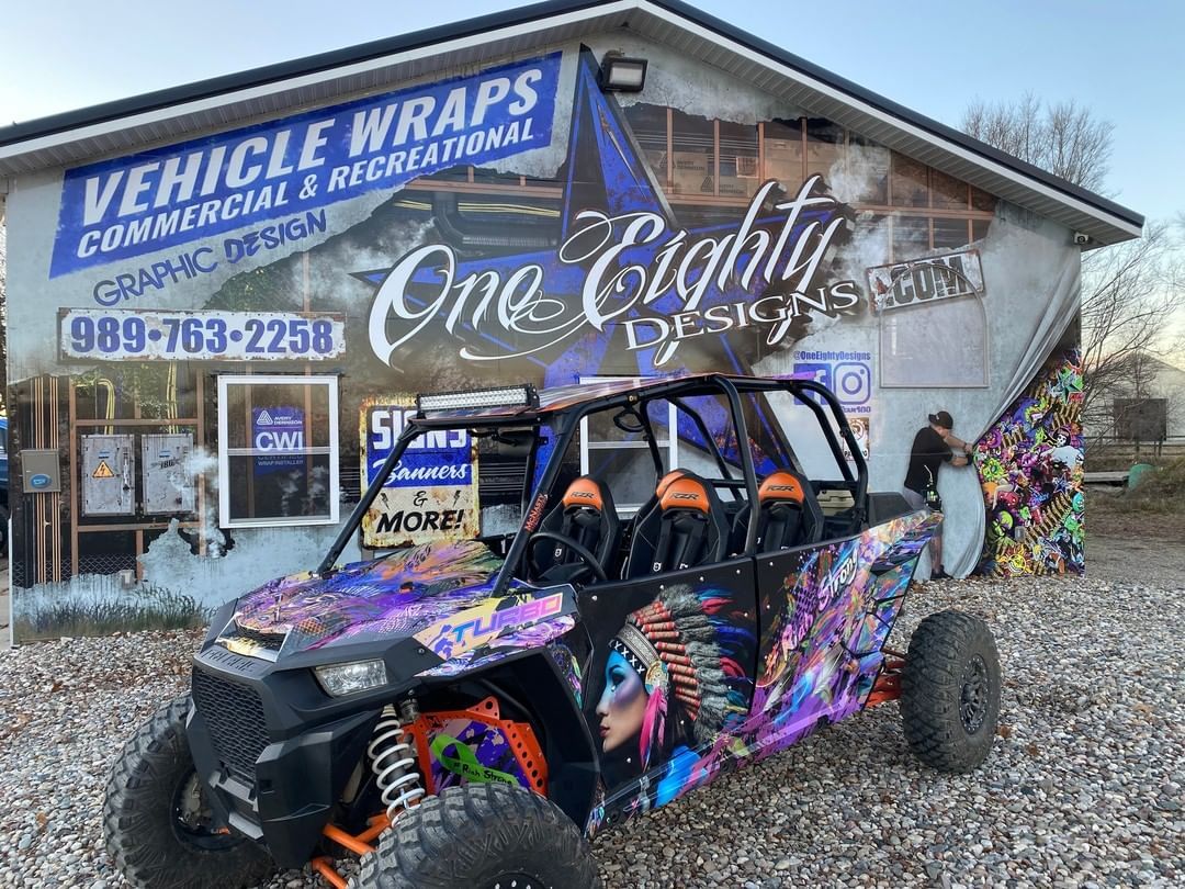 A purple and orange atv is parked in front of a building.