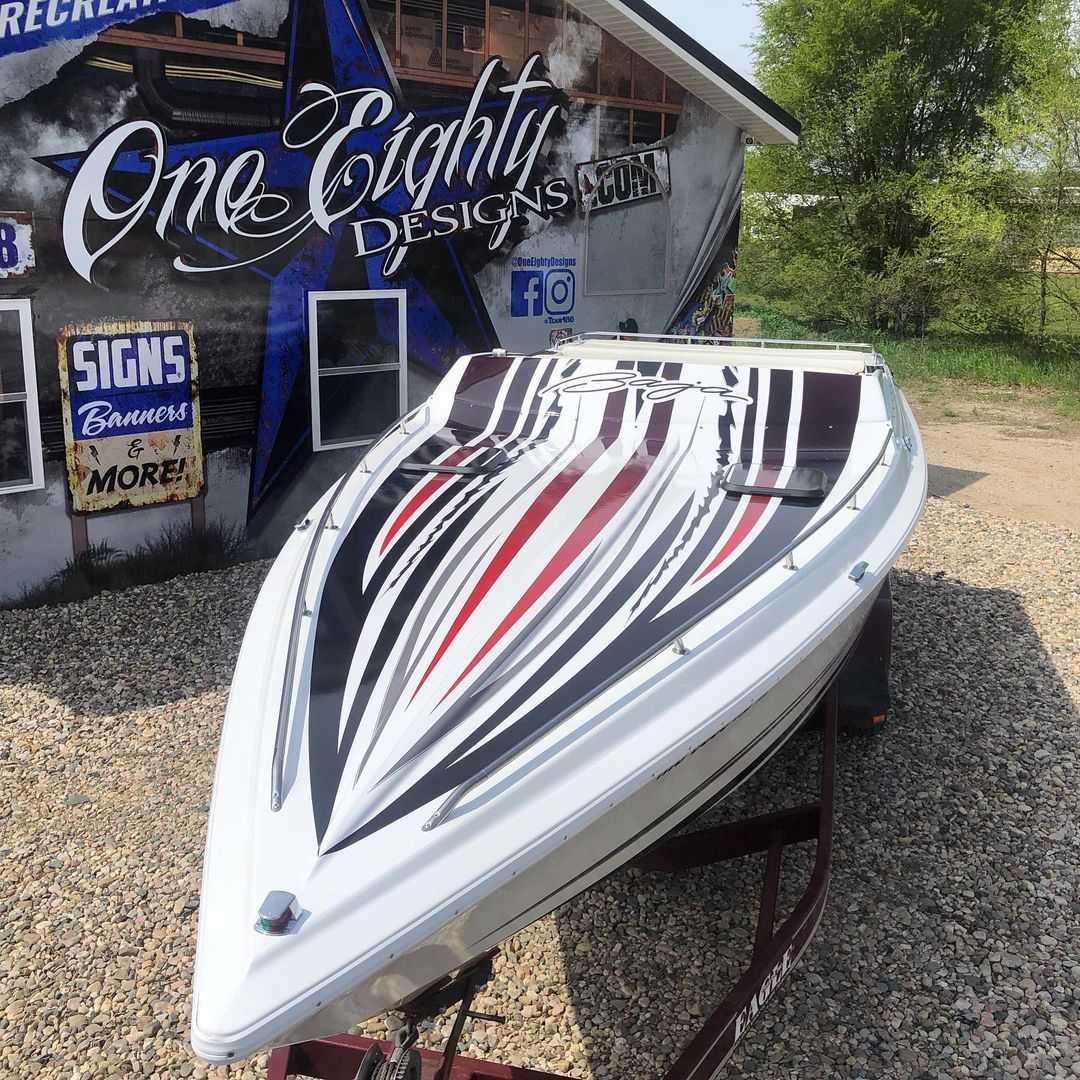 A boat is parked in front of a building that says one eighty design