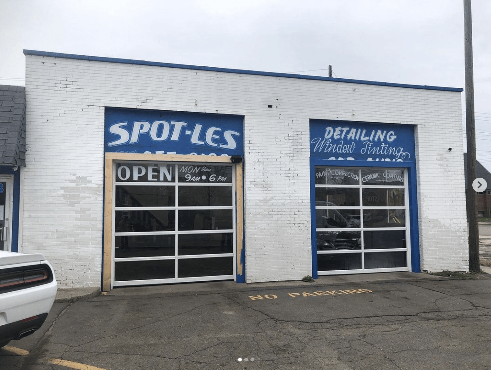 A white building with a blue sign that says spots on it