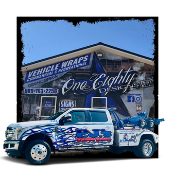 A white tow truck is parked in front of a building.