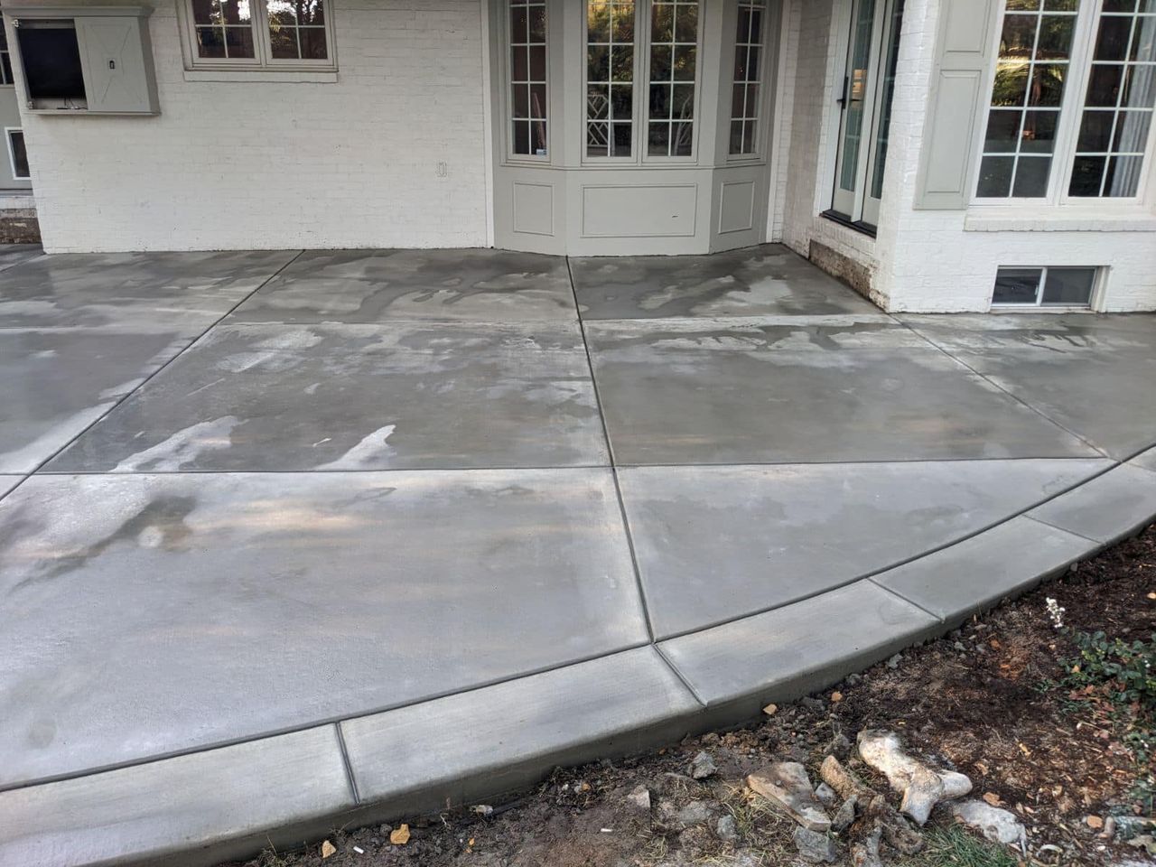 A concrete walkway is being built in front of a white house.