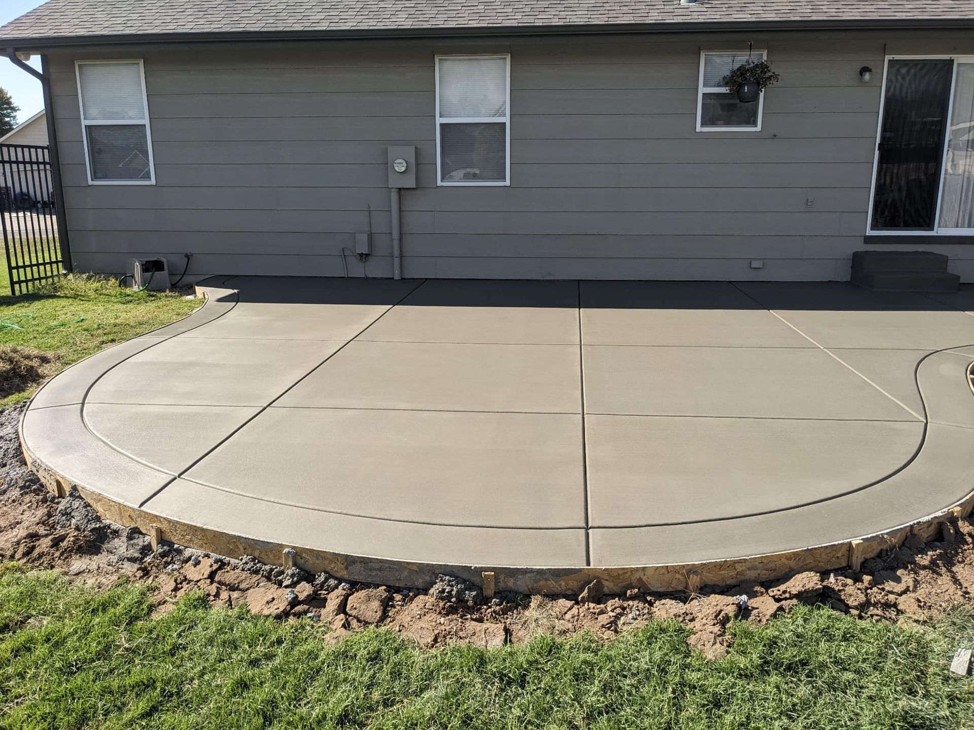 A concrete patio is being built in front of a house.