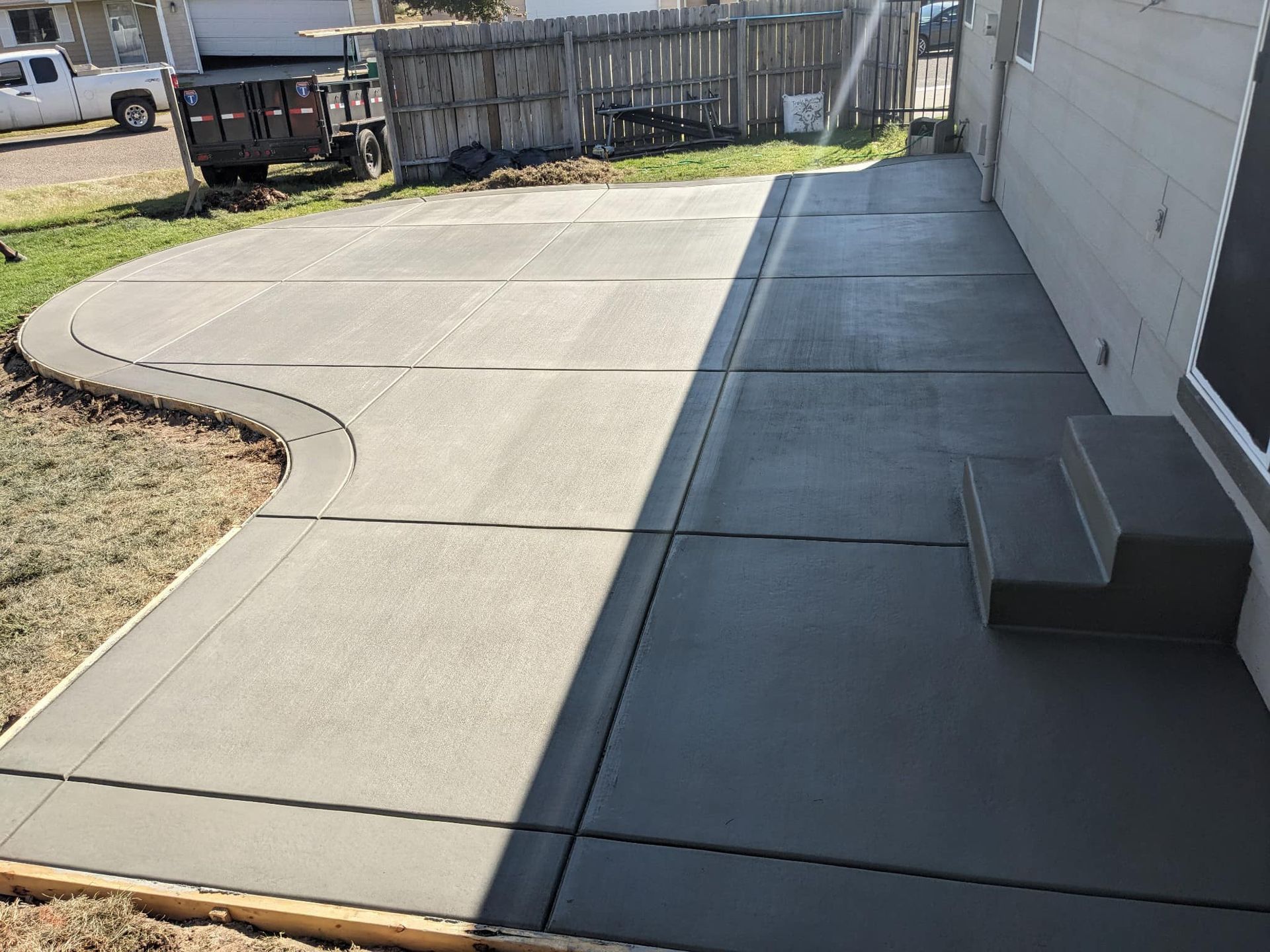A concrete walkway is being built in front of a house.