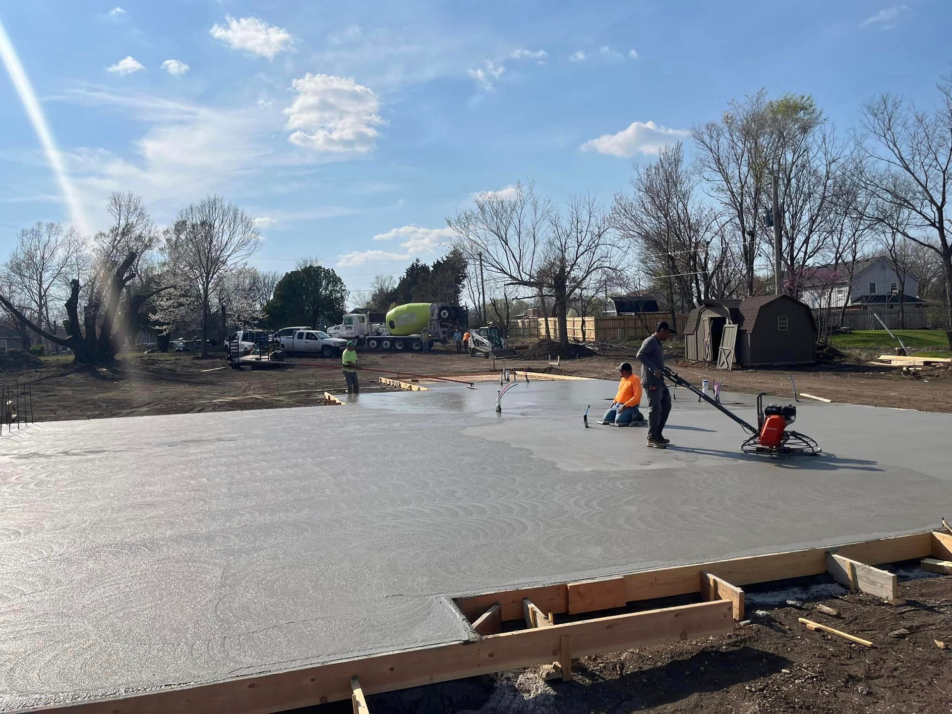 A man is laying concrete on a construction site.
