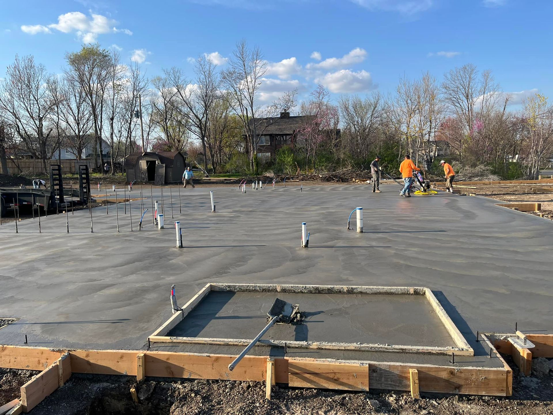 A group of construction workers are working on a concrete foundation.
