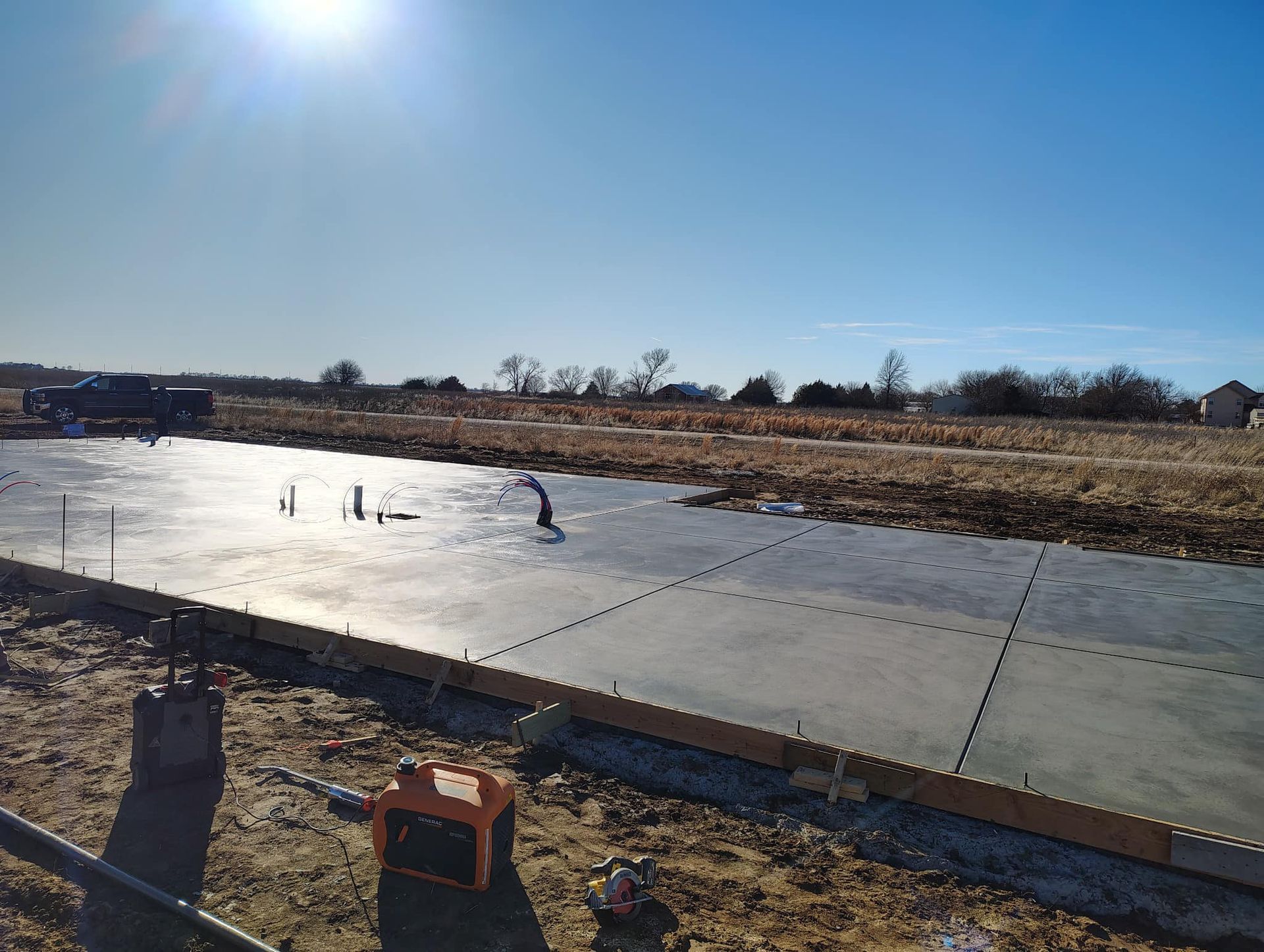 A concrete driveway is being built on a sunny day