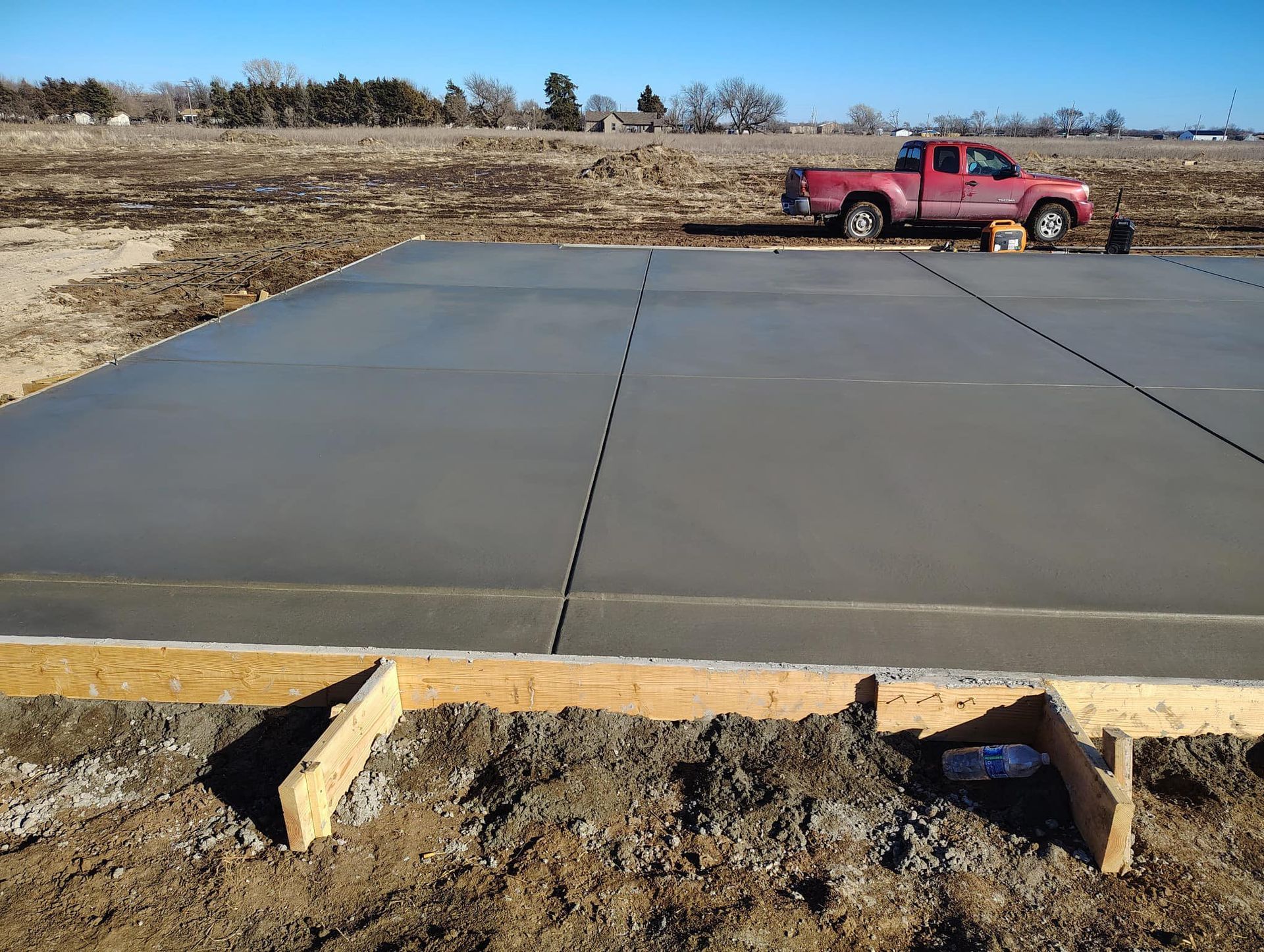 A red truck is parked on a concrete slab
