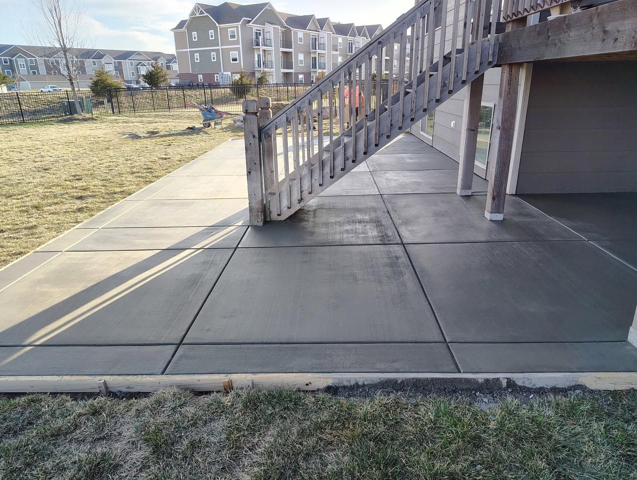 A concrete walkway with stairs leading up to a deck.