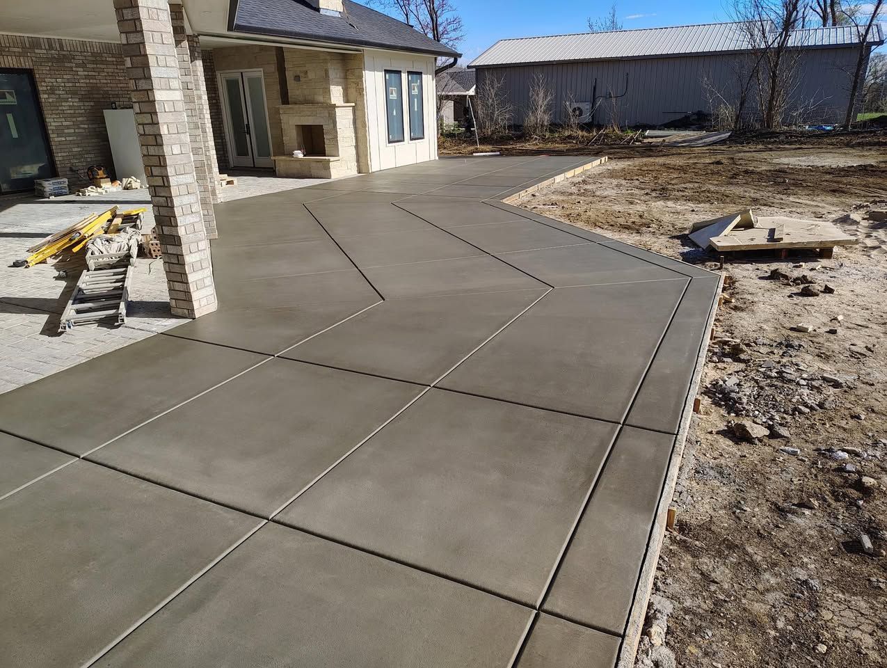 A concrete driveway is being built in front of a house.
