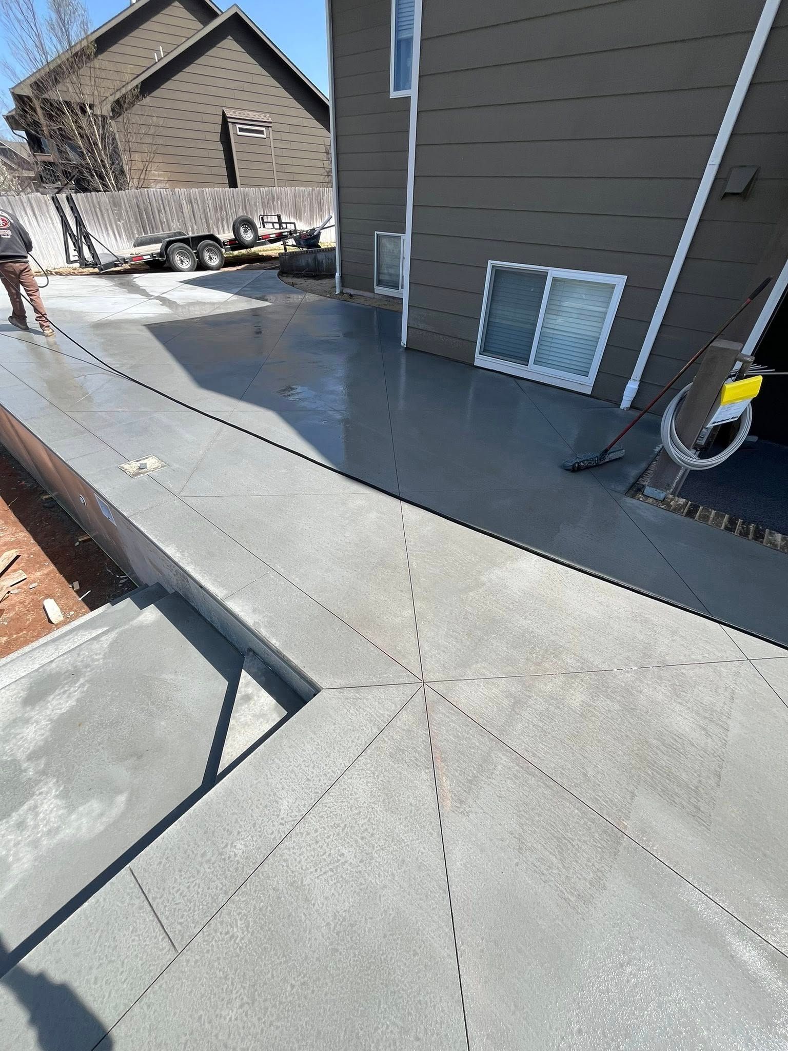 A concrete driveway is being built in front of a house.