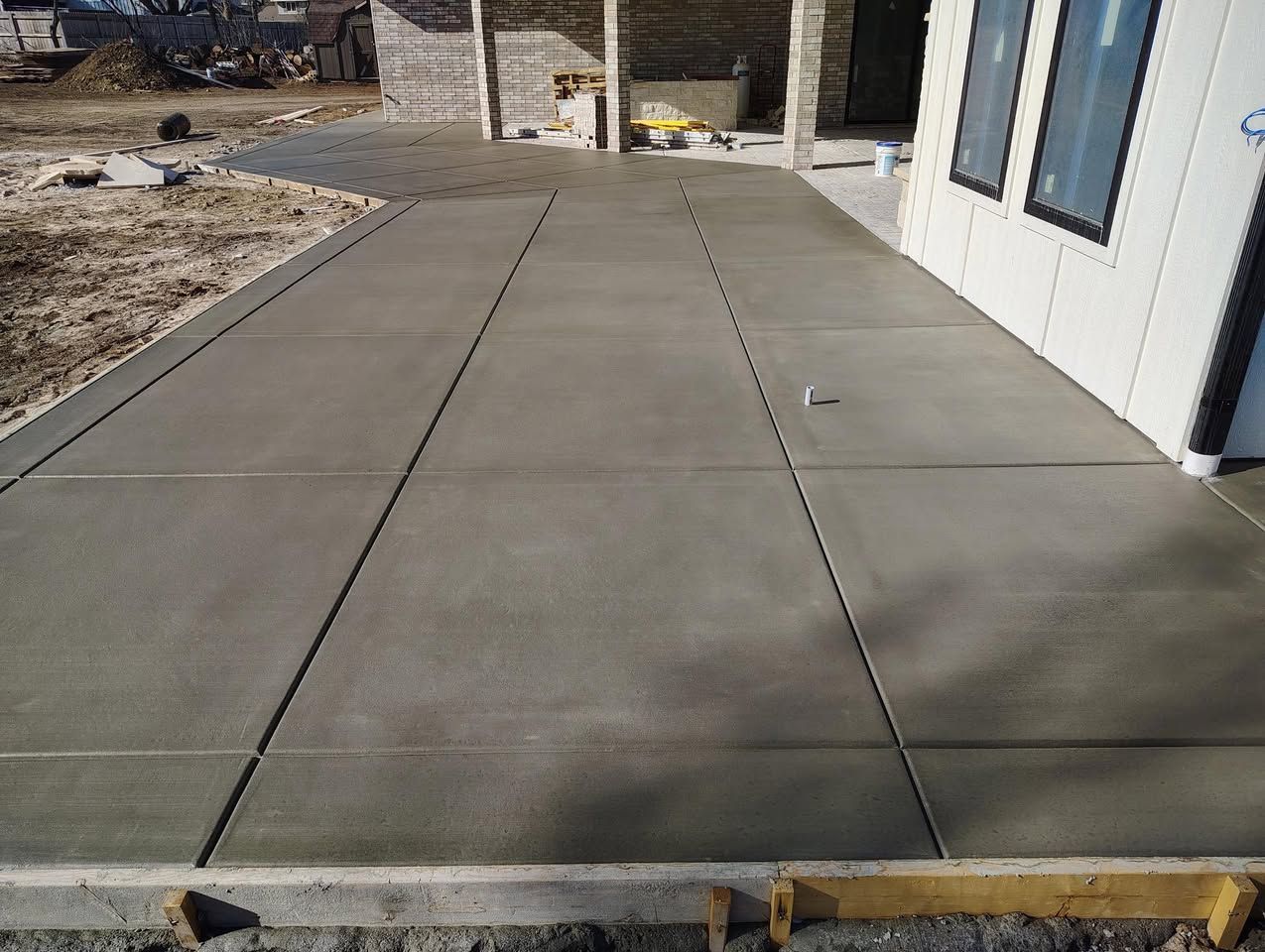 A concrete walkway is being built in front of a house.