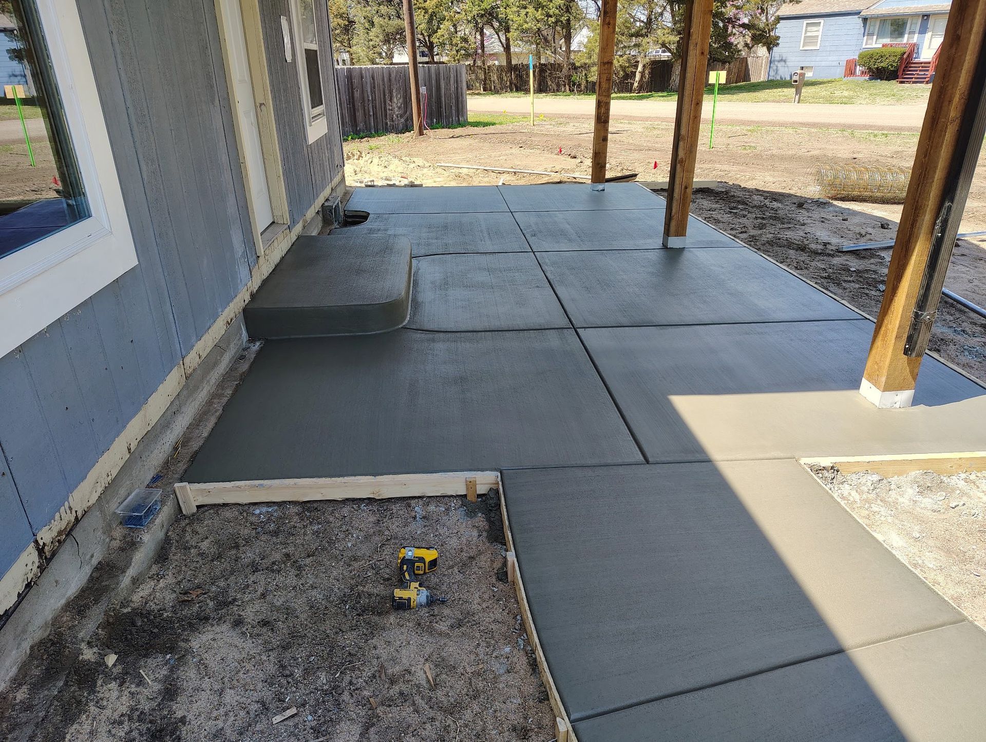 A concrete walkway is being built in front of a house.
