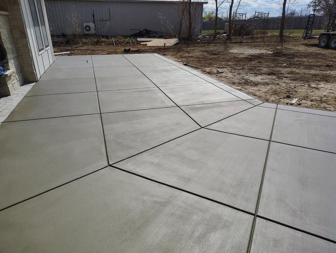 A concrete driveway is being built in a backyard.