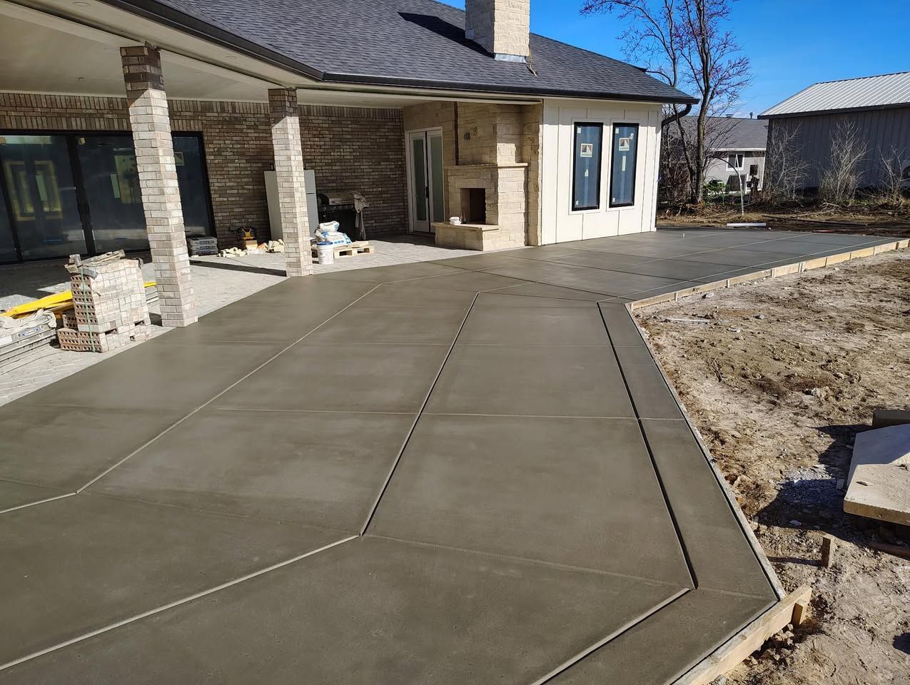 A concrete driveway is being built in front of a house.