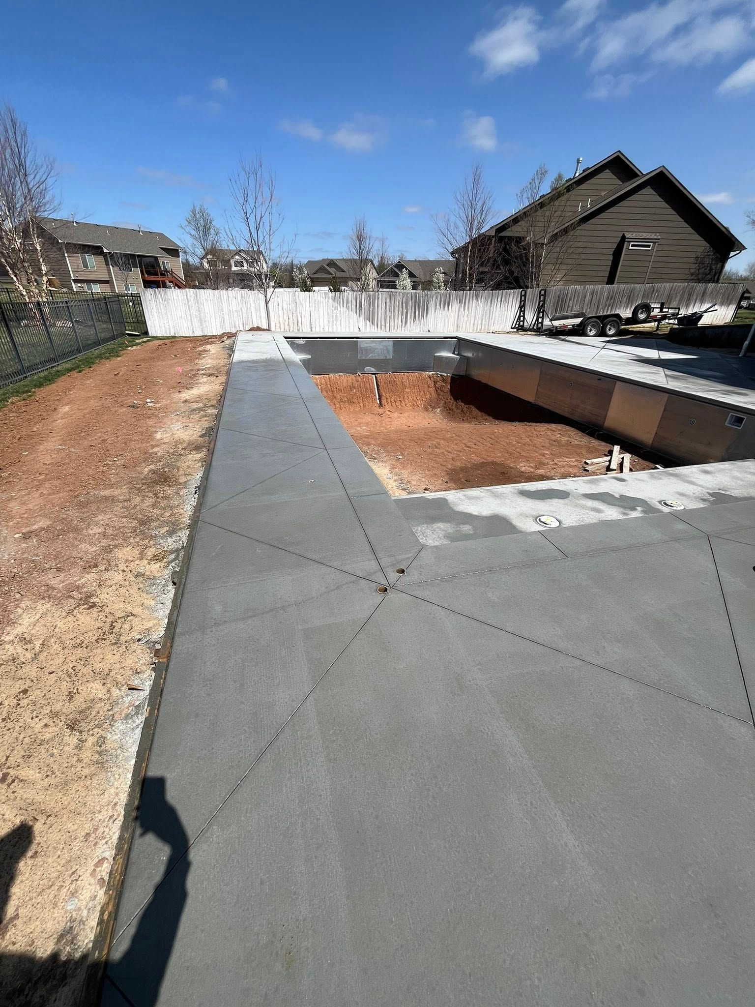 A concrete walkway leading to a house in a residential area.