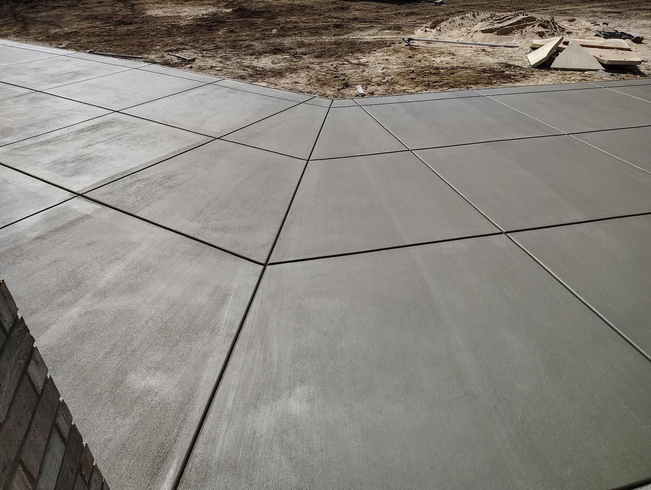 A concrete walkway is being built in a yard.