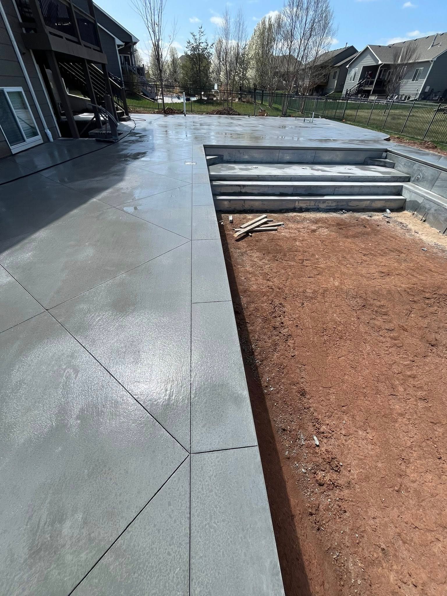 A concrete patio with steps leading up to a house.
