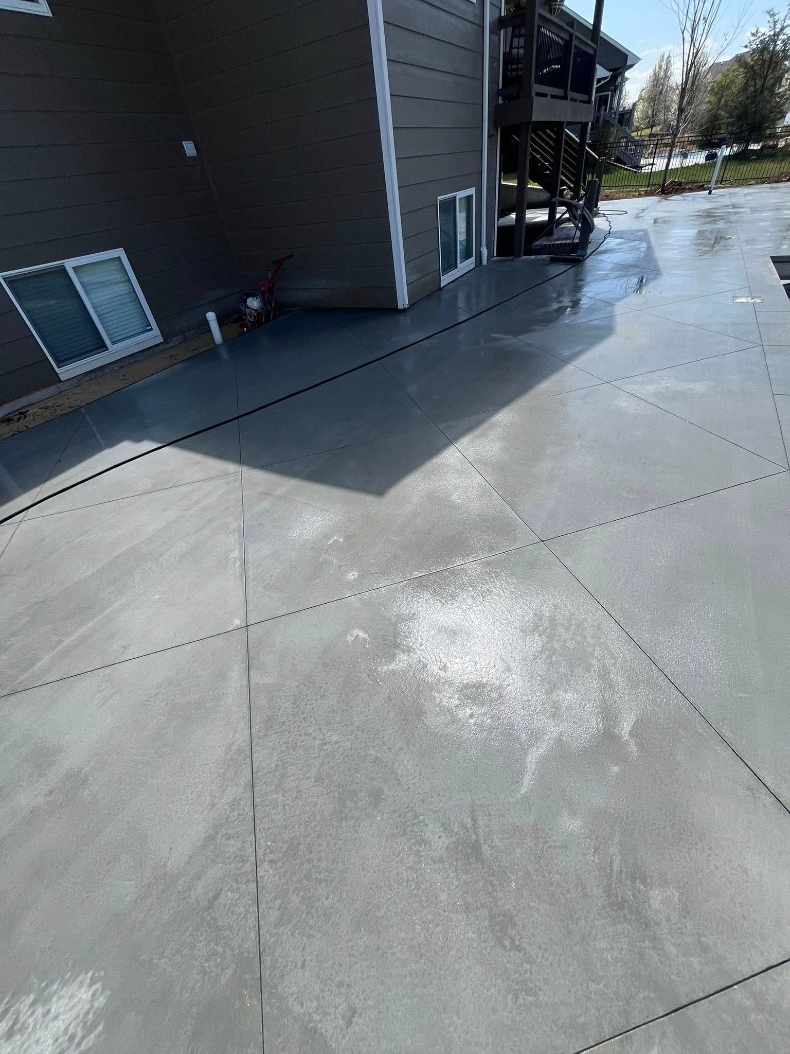 A concrete driveway with a house in the background.