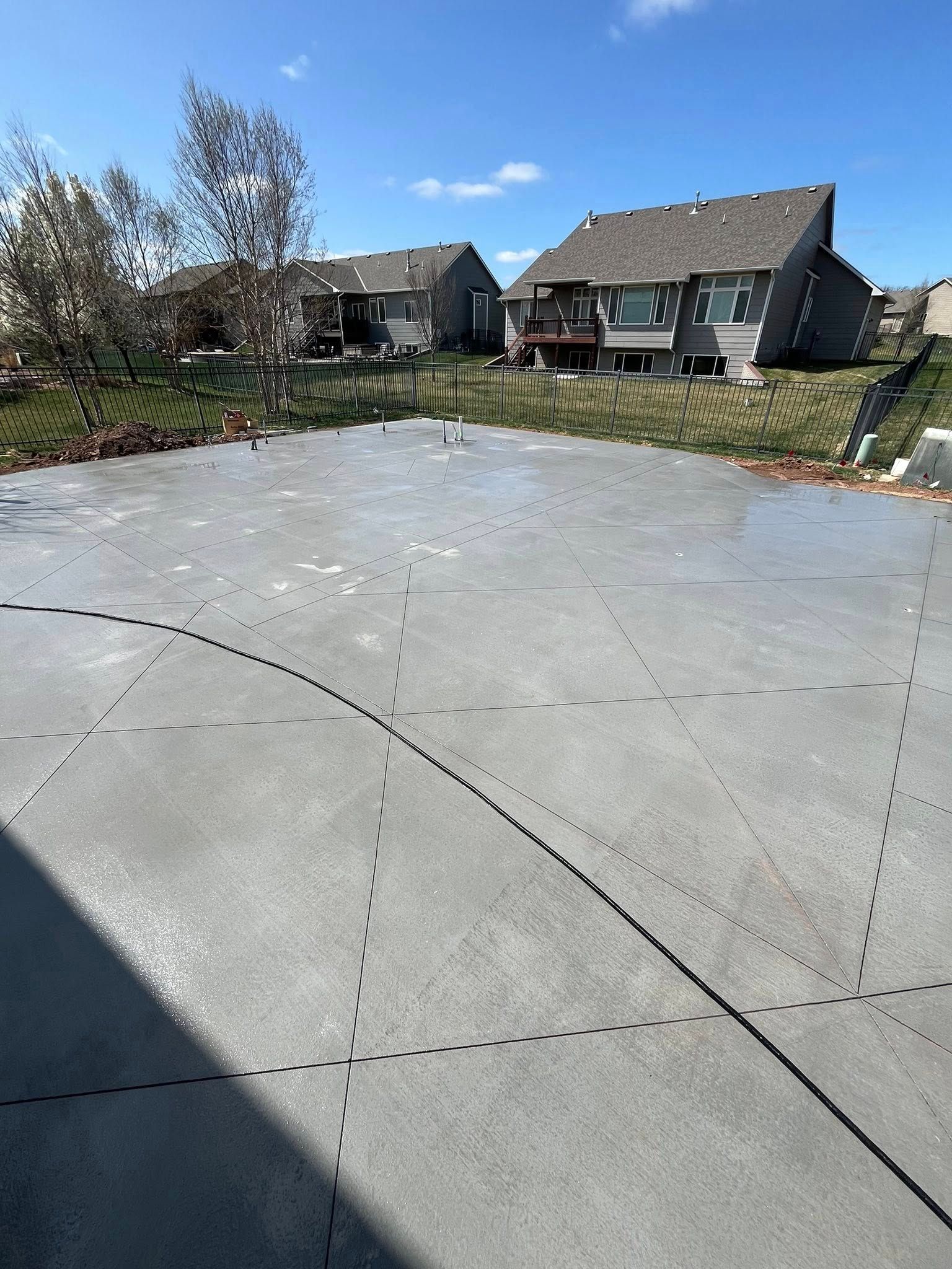 A concrete driveway with a lot of houses in the background.