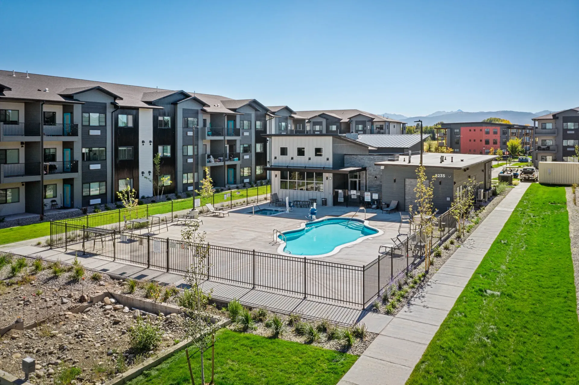 Aerial view of a modern apartment complex with a central pool and clubhouse.
