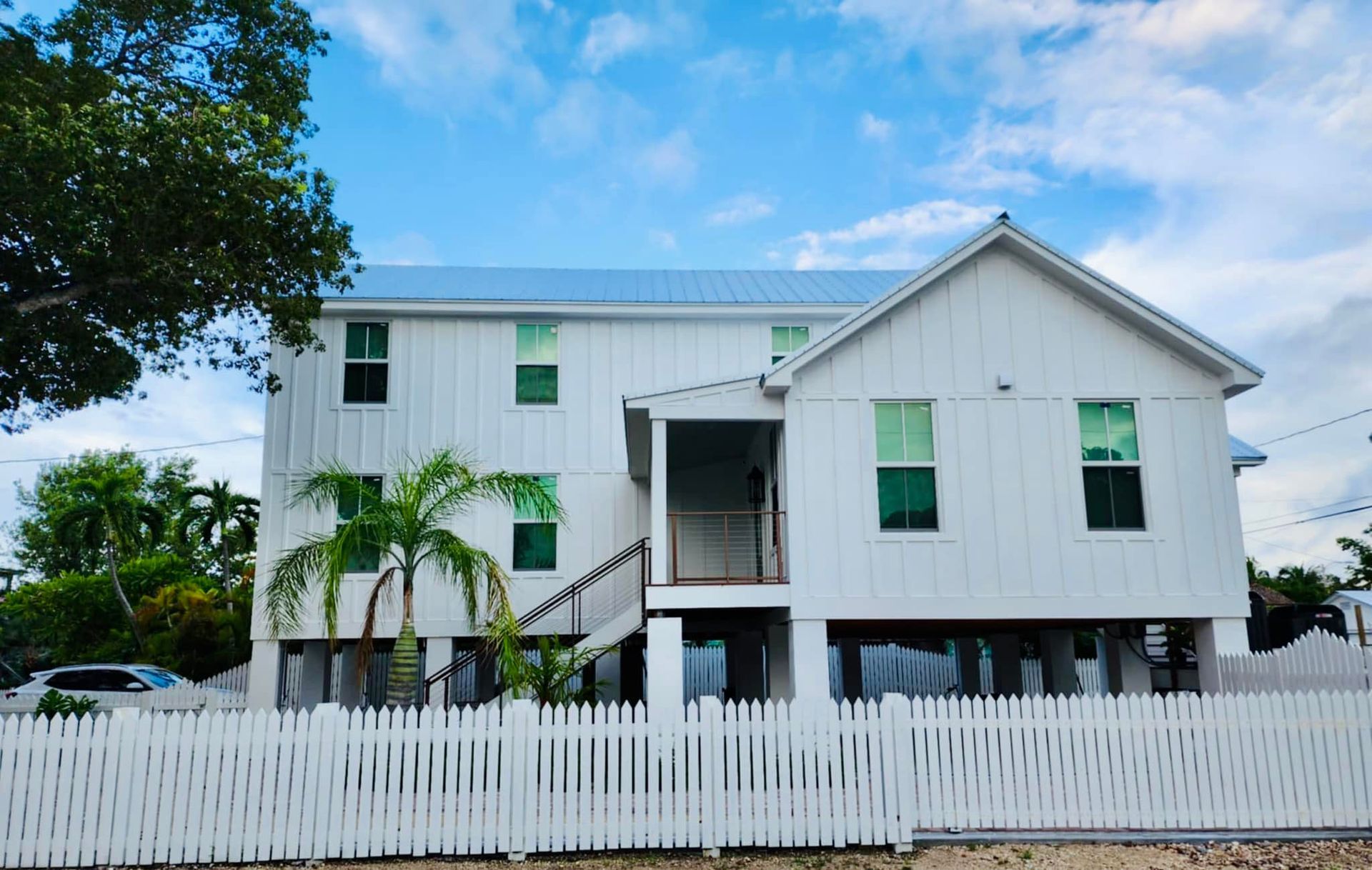 A white house with a white picket fence in front of it