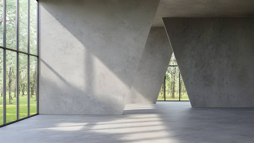 Empty concrete room with large windows, sunlight casting geometric shadows on the floor and wall