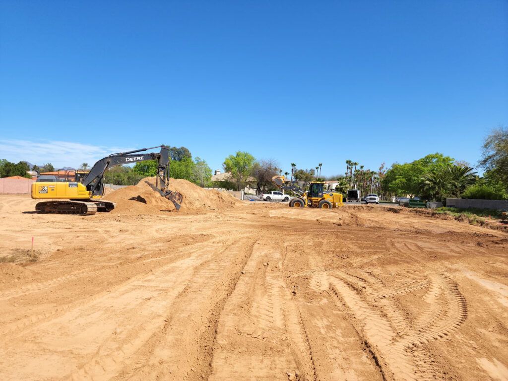 Wet concrete pouring from a truck chute onto a construction site, forming a gravelly slab surface
