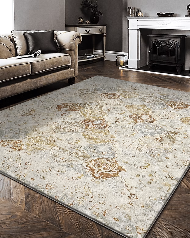 Light beige patterned area rug on a dark wood floor in a living room near a sofa and fireplace