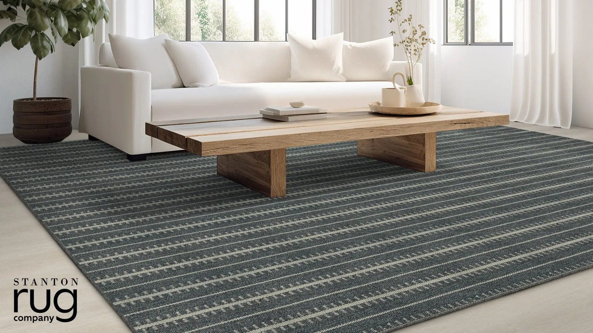 White sofa and wooden coffee table on a dark patterned rug in a bright living room