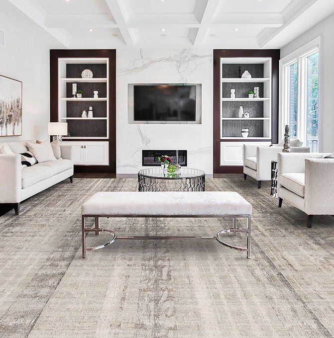 Modern living room with white sofa, marble fireplace, TV, built-in shelves, and beige bench on a gray rug