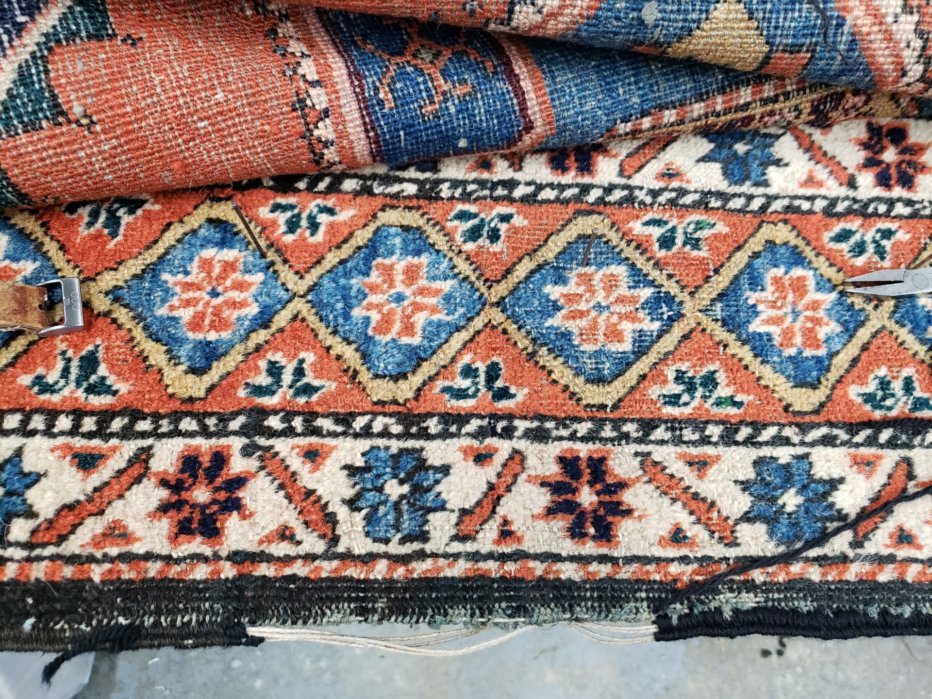 Close-up of a colorful woven rug with blue, orange, and cream geometric patterns